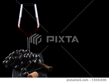Glass of red wine with dark grapes and vintage 53042690