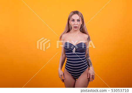 Playfull young woman in luxury swimming suit ready for going to the beach Playfull young woman in luxury swimming suit ready for going to the beach 53053710