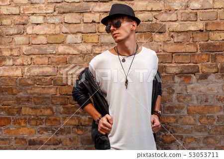 Trendy young man with sunglasses in a black hat Trendy young man with sunglasses in a black hat 53053711