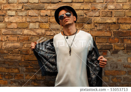 Handsome young man with sunglasses in a black hat Handsome young man with sunglasses in a black hat 53053713
