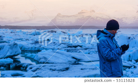 Asian man using smart phone at jokulsarlon, Asian man using smart phone at jokulsarlon, 53115828