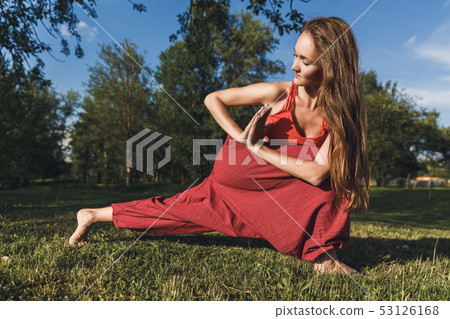 Young woman doing yoga exercises in the summer city park. Health lifestyle concept. 53126168