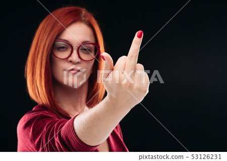 Confident and angry red haired girl showing finger Confident and angry red haired girl showing finger 53126231