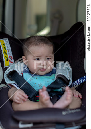 Baby sitting on a child seat 53127708