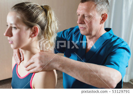 Male manual visceral therapist masseur treats a young female patient. Warm up the shoulders and neck 53129791