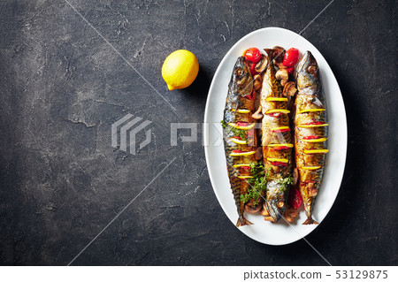 three broiled mackerels on an oval dish 53129875