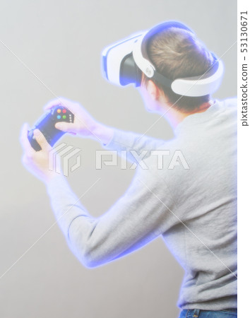 Man with virtual reality headset is playing game. Image with hologram effect. Man with virtual reality headset is playing game. Image with hologram effect. 53130671