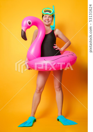 Full-length photo of woman in swimsuit with lifebuoy and flippers on empty orange background Full-length photo of woman in swimsuit with lifebuoy and flippers on empty orange background 53131624