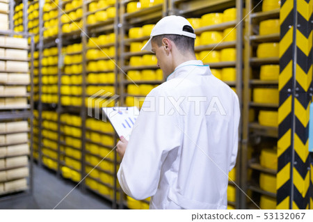 Portrait of inspector standing in production department of dairy factory and take view of redy Portrait of inspector standing in production department of dairy factory and take view of redy 53132067
