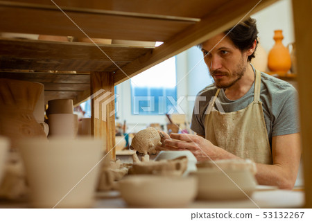 Thoughtful dark-haired master observing his collection and choosing Thoughtful dark-haired master observing his collection and choosing 53132267