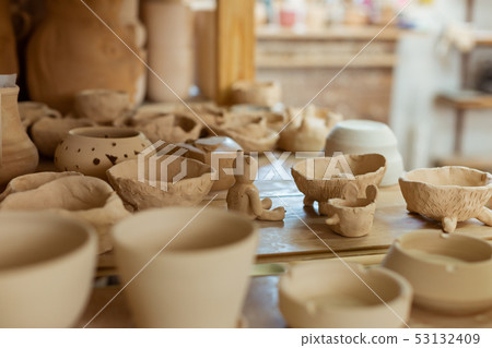 Bunch of fresh unprocessed clay pots placed on a working surface Bunch of fresh unprocessed clay pots placed on a working surface 53132409
