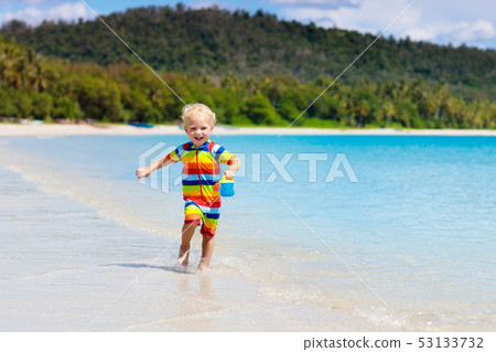 Kids play on tropical beach. Sand and water toy. 53133732
