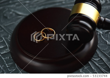 Two broken golden wedding rings divorce decree document. Divorce and separation concept Two broken golden wedding rings divorce decree document. Divorce and separation concept 53133744