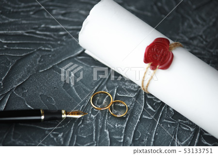 Two broken golden wedding rings divorce decree document. Divorce and separation concept Two broken golden wedding rings divorce decree document. Divorce and separation concept 53133751