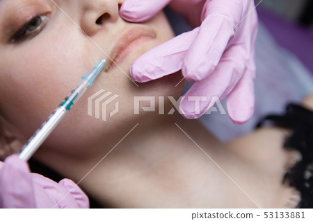 The doctor cosmetologist makes the Rejuvenating facial injections procedure for tightening and 53133881