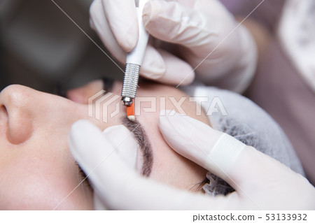 Permanent Makeup For Eyebrows. Microblading brow. Beautician Doing Eyebrow Tattooing For Female Face 53133932