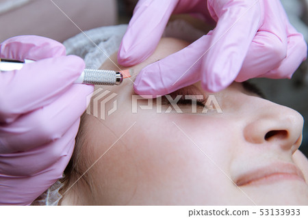 Permanent Makeup For Eyebrows. Microblading brow. Beautician Doing Eyebrow Tattooing For Female Face 53133933