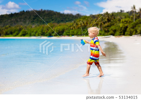 Kids play on tropical beach. Sand and water toy. Kids play on tropical beach. Sand and water toy. 53134015