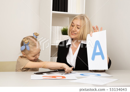 Female teacher with girl patient learning pronunciation. Female teacher with girl patient learning pronunciation. 53134043