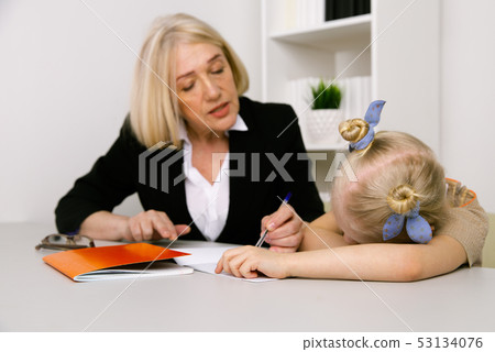 Granddmother and granddaughter doing homework together. Granddmother and granddaughter doing homework together. 53134076