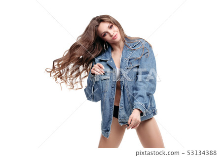 Pretty woman in denim jacket dancing in studio on 53134388