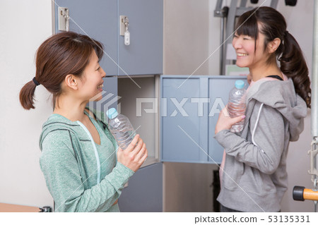 Woman chatting at gym gym locker Woman chatting at gym gym locker 53135331