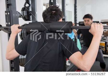 Men squatting in the gym Men squatting in the gym 53136267