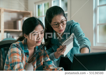 Two asian women colleagues working with laptop Two asian women colleagues working with laptop 53136580