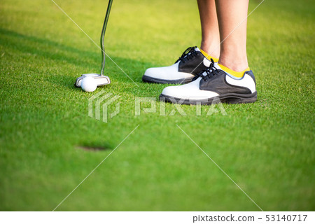 Close up golfer legs approach golf ball  putting 53140717
