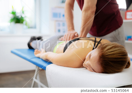 Pleasant relaxed woman receiving a back massage 53145064