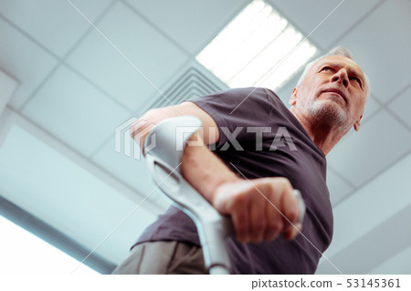 Low angle of a pleasant aged man walking 53145361