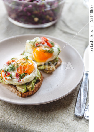 Breakfast served of two toasts with avocado, fried Breakfast served of two toasts with avocado, fried 53148652