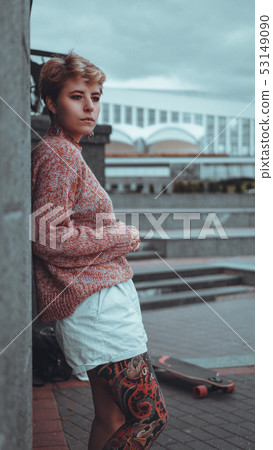 Beautiful young girl with tattoos with longboard 53149090