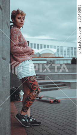 Beautiful young girl with tattoos with longboard 53149093