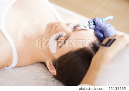 Eyelashes extensions. Fake Eyelashes. Eyelash Extension Procedure. Professional stylist lengthening Eyelashes extensions. Fake Eyelashes. Eyelash Extension Procedure. Professional stylist lengthening 53152565