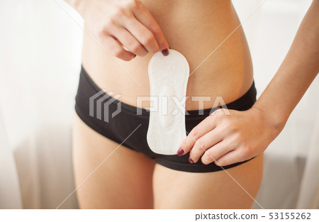 Female Hygiene. Closeup Of Beautiful Woman With Fit Slim Body In White Underwear Holding Sanitary Female Hygiene. Closeup Of Beautiful Woman With Fit Slim Body In White Underwear Holding Sanitary 53155262