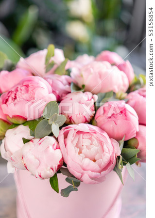 Pink peonies on the old grey table. Beautiful peony flower for catalog or online store. Floral shop 53156854