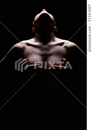 Nude Woman silhouette under light in the dark 53161007