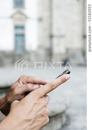 man using his smartphone on the street. man using his smartphone on the street. 53162053