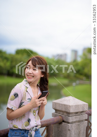 Young beautiful Asian tourist woman relaxing at the park 53162953