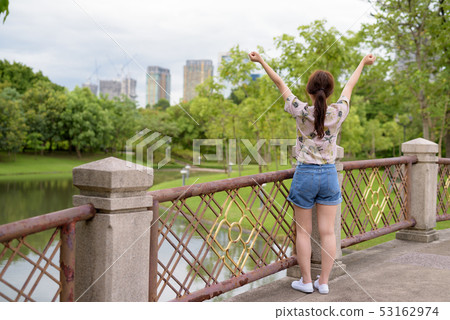 Young beautiful Asian tourist woman relaxing at the park 53162974
