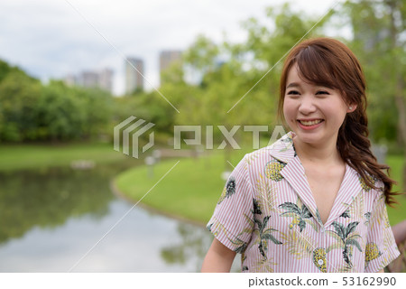 Young beautiful Asian tourist woman relaxing at the park 53162990