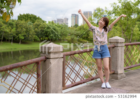 Young beautiful Asian tourist woman relaxing at the park 53162994