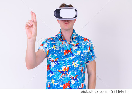 Portrait of young tourist man touching air while using virtual reality headset Portrait of young tourist man touching air while using virtual reality headset 53164611