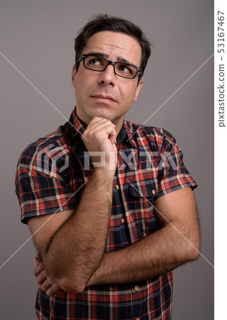 Handsome Persian man wearing eyeglasses against gray background Handsome Persian man wearing eyeglasses against gray background 53167467