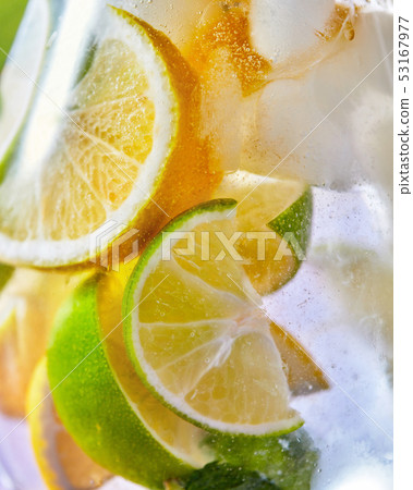 Macro citrus drink background with lemon and lime slices in a glass. 53167977
