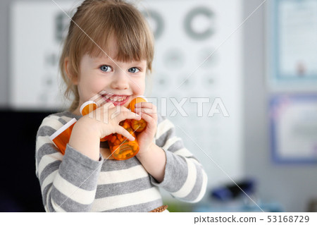 Cute smiling happy little girl grab pile of bottles with tablets Cute smiling happy little girl grab pile of bottles with tablets 53168729