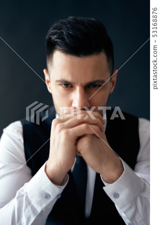 Handsome thoughtful man portrait in suit on dark background Handsome thoughtful man portrait in suit on dark background 53168876