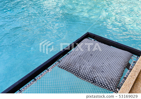 Mesh seat with pillows jut out on swimming pool 53169029