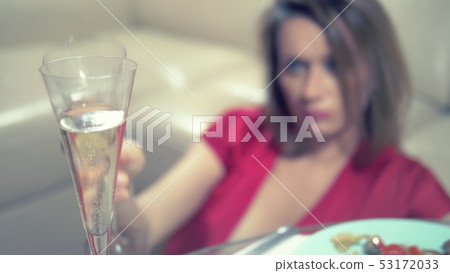 woman gets drunk at home alone at a table set for two for a romantic date, as her partner did not woman gets drunk at home alone at a table set for two for a romantic date, as her partner did not 53172033